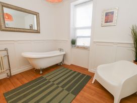 A bathroom with a bathtub and a plant at The Beach Condo in Weymouth