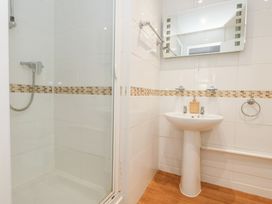 A bathroom with a shower and sink at The Beach Condo in Weymouth