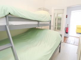 A bedroom with a bunk bed and green bedding at The Beach Condo in Weymouth