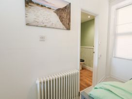 A bedroom with a radiator and a door leading to a toilet at The Beach Condo in Weymouth