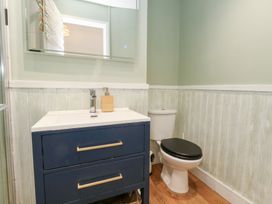 A bathroom with a sink, toilet, and mirror at The Beach Condo in Weymouth