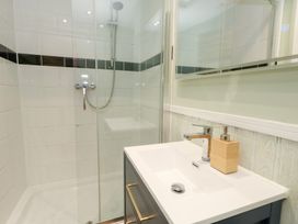A bathroom featuring a shower and sink at The Beach Condo in Weymouth