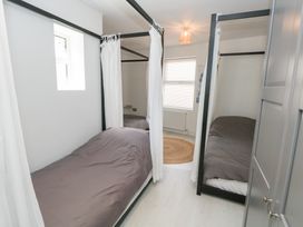 A bedroom with two single beds and a window at The Beach Condo in Weymouth