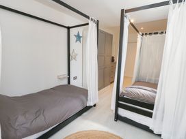 A bedroom with two beds and a wardrobe at The Beach Condo in Weymouth
