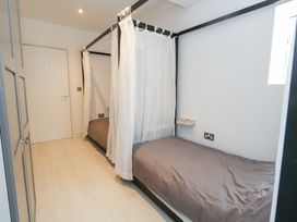 A bedroom with two beds and curtains at The Beach Condo in Weymouth