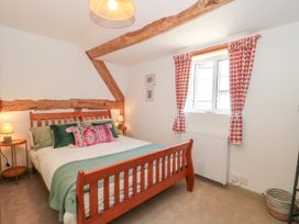A bedroom with a bed and curtains at Old Farm Cottage in Warminster