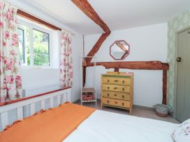 A bedroom with bed and mirror at Old Farm Cottage in Warminster