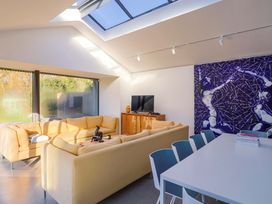 A living room with a sofa and dining table at 2 Bredy Cottages in Burton Bradstock