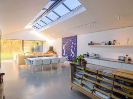 A living room with dining area and kitchen appliances at 2 Bredy Cottages in Burton Bradstock