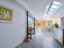 A kitchen with a glass wall and dining area at 2 Bredy Cottages Burton Bradstock