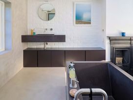 A bathroom with a sink and cabinet at 2 Bredy Cottages in Burton Bradstock