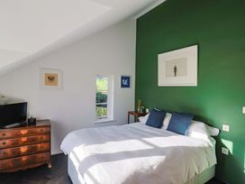A bedroom with a bed and television at 2 Bredy Cottages in Burton Bradstock