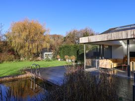 An outdoor area with a pool and seating at 2 Bredy Cottages in Burton Bradstock