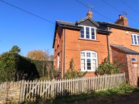 A brick house with a fence and garden at 2 Bredy Cottages Burton Bradstock