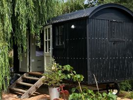 A shepherd's hut with steps and plants at 2 Bredy Cottages Burton Bradstock
