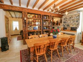 A dining room with a wooden table and chairs and decorated shelves at Shaftoe Mews in Haydon Bridge