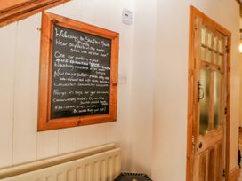 A hallway with a wooden framed blackboard on the wall and a wooden door at Shaftoe Mews in Haydon Bridge