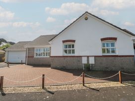 A house with a paved driveway and garage at Jaluna in Carbis Bay