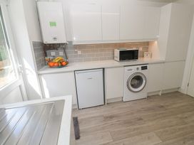 A kitchen with a washing machine and microwave at Jaluna in Carbis Bay