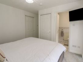A bedroom with a bed and doors leading to a bathroom at Jaluna in Carbis Bay