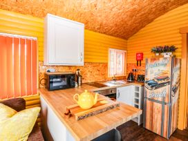 A kitchen with a countertop, sink, microwave and refrigerator at Ava Lodge West Mains near Haggerston