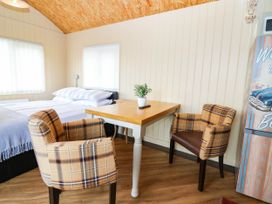A bedroom with a bed and table with chairs at Masons Hut in West Mains near Haggerston