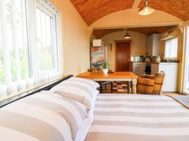 A living room with a bed and table at Masons Hut near Haggerston