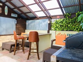 An outdoor dining area with bar stools and a table at Masons Hut in West Mains near Haggerston