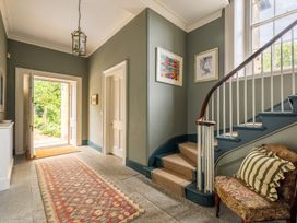 A hallway with a staircase and door leading outdoors at The Old Vicarage in Merriott