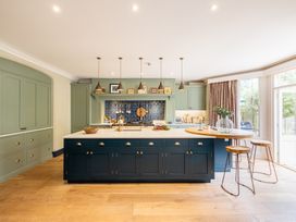 A kitchen with an island and stools at The Old Vicarage in Merriott