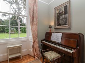 A music room with a piano and sheet music at The Old Vicarage in Merriott