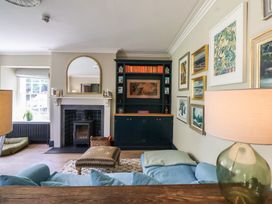 A living room with a fireplace and bookshelf at The Old Vicarage in Merriott