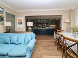 A dining room with a blue sofa and a table at The Old Vicarage in Merriott