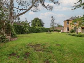 A garden with a tree, bench, and hedges at The Old Vicarage in Merriott