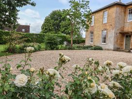 A garden with roses and a gravel area at The Old Vicarage in Merriott