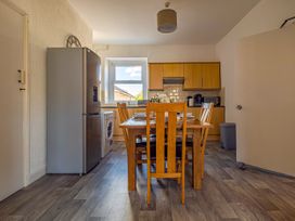 A kitchen with a dining table and appliances at Flat 56 Newton Road Abertawe