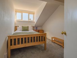 A bedroom with a wooden bed and nightstand at Flat 56 Newton Road Abertawe