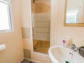A bathroom with a shower cubicle sink and a window at GM18 in Clarach Bay near Aberystwyth