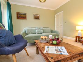 A living room with a sofa and fruit bowl at Corner Cottage in Preston