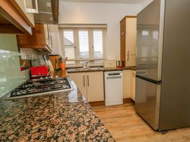 A kitchen with a gas stove and fridge at Corner Cottage Preston