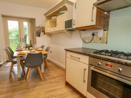 A kitchen with a dining table and cooking appliances at Corner Cottage in Preston