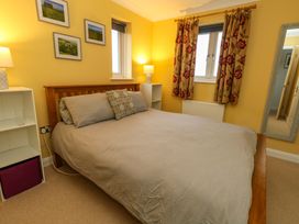 A bedroom with a bed and shelves at Corner Cottage Preston