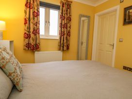 A bedroom with a bed and lamp at Corner Cottage in Preston