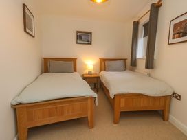 A bedroom with two beds and a nightstand at Corner Cottage in Preston