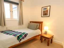 A bedroom with a bed and nightstand at Corner Cottage in Preston