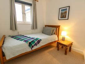 A bedroom with a bed and lamp at Corner Cottage in Preston