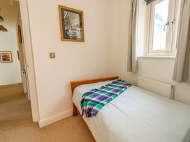 A bedroom with a bed and framed picture at Corner Cottage Preston