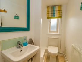 A bathroom with a sink, toilet, and window at Corner Cottage in Preston