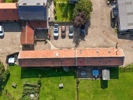 An outdoor area with buildings, cars, and a hot tub at Mini pod Staintondale near Burniston