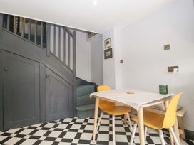 A dining room with a table and yellow chairs at Elm Cottage Moreton-In-Marsh